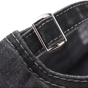 Close-up of the metal buckle and adjustable fabric strap on a vintage cotton baseball cap