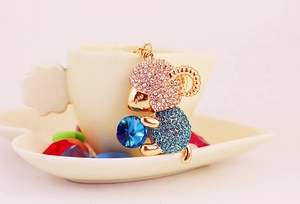Macro shot of a gold sheep keychain with sparkling pink and blue crystal rhinestones