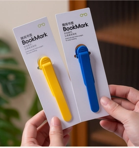 Detail of blue and yellow auto-follow bookmarks with metal spring on paper packaging