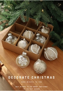 Detail of 9-piece gold and white Christmas ball set with snowflake patterns on wood