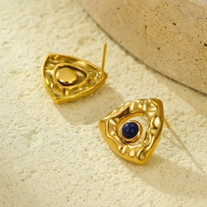 Macro shot of gold triangular stud earrings with textured surface and blue gemstone