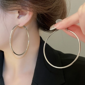 Close-up of minimalist silver hoop earrings worn by model showing metallic luster