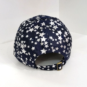 Detail of navy baseball cap featuring white star patterns and adjustable bronze buckle