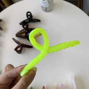 Detail shot of a large fluorescent yellow 11cm claw clip with a durable metal spring