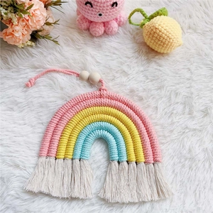 Detailed macro view of handmade cotton rainbow wall decor with tassels and wooden beads