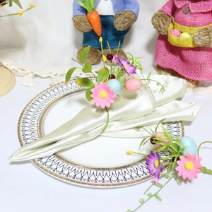 Easter napkin ring with pastel eggs and daisies on a ceramic plate for table decor
