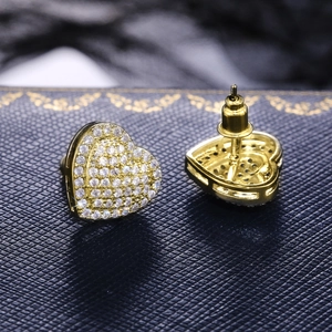Elegant gold heart stud earrings with white micro-pave cubic zirconia on blue jewelry box