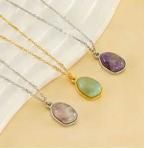Detailed macro view of water-drop natural stone pendants on gold and silver steel chains