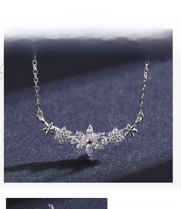 Macro detail of S925 silver necklace featuring five flower charms with white zircon stones