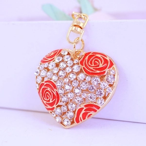 Porte-clés cœur doré avec cristaux brillants et détails de rose en émail rouge