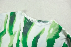 Detail of round neckline with high-quality stitching on green and white printed dress