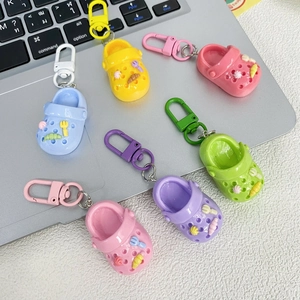 Colorful mini clog shoe keychains in six pastel colors on a modern desk setup