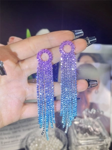 Detail of long fringe rhinestone earrings with a purple to blue gradient finish