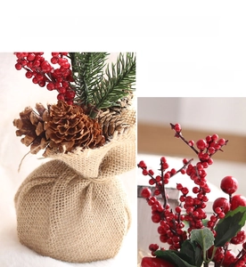 Detail of mini Christmas tree with burlap base, natural pine cones and red berries