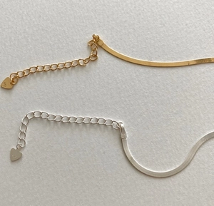 Detail of 925 sterling silver flat snake chain necklaces with heart-shaped extender tag