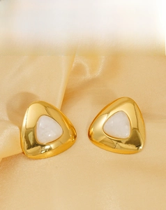 Detailed view of luxury triangle stud earrings with gold plating and white inlay on silk