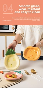 Detail of cute fruit shaped ceramic plates with strawberry and pineapple patterns