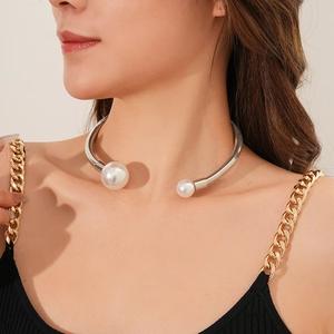Close-up of silver metal choker with white pearls worn on a model's neck