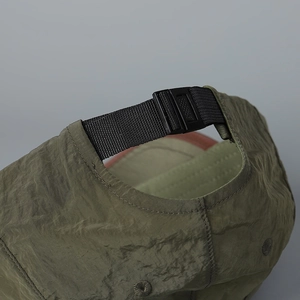 Détail d'une casquette olive à séchage rapide avec boucle réglable et texture en nylon