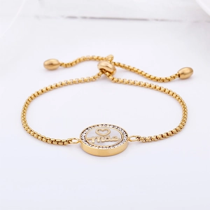 Detailed close-up of golden box chain bracelet featuring a crystal-encrusted Mãe pendant