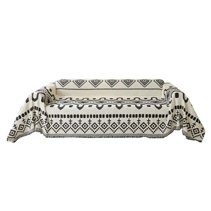 Bohemian chenille sofa cover with black geometric patterns and decorative fringe trim