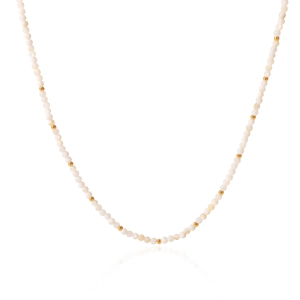 Detail of elegant white bead necklace with small gold spacers on white background