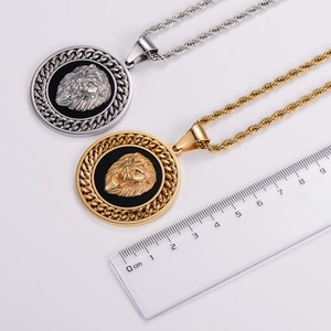 Gold and silver lion head pendant necklace with twisted rope chain shown with ruler