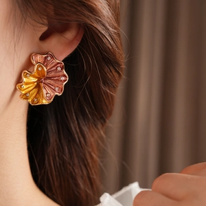 Close-up of vintage shell-shaped earrings with gold-brown enamel and sparkling rhinestones