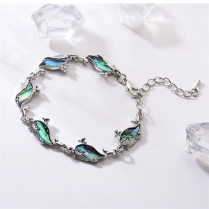Detailed view of silver whale bracelet featuring shimmering blue shell inlays on white