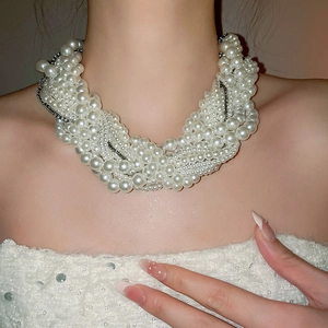 Detail of multi-layer beaded pearl choker showing glossy texture and stacked design