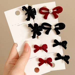 Elegant red and black velvet bow hair clips with pearls on a professional display card