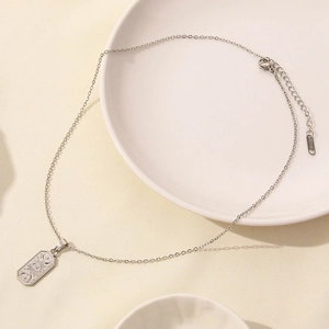 Detail of silver stainless steel necklace with engraved sun and moon tarot pendant