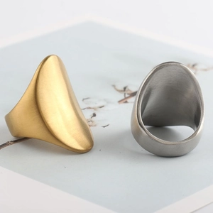 Close-up of gold and silver chunky oval rings with a brushed metallic texture