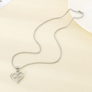 Macro shot of silver heart pendant with Mom lettering and sparkling rhinestones