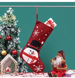 Detail eines roten Weihnachtsstrumpfs aus Stoff mit Schneemann und Schneeflocken am Ständer