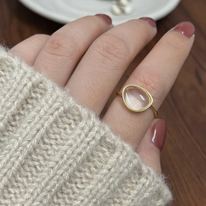 Close-up of a 925 silver gold-plated ring with clear crystal stone on a finger