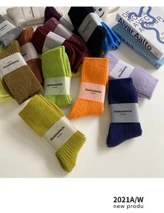Close-up of colorful ribbed wool blend socks in various vibrant colors on a white desk