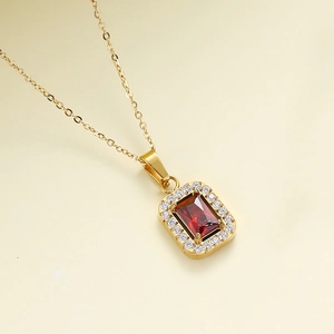 Detail showing gold rectangular pendant with red zircon stone and micro-pave setting