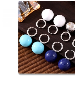 Vista dettagliata di orecchini a sfera colorati in bianco, blu e finitura argento metallico