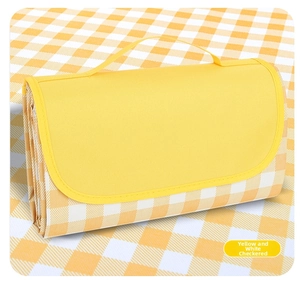 Folded yellow and white plaid picnic mat with a portable handle for outdoor camping use