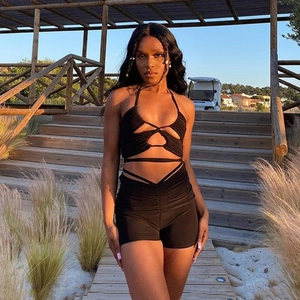 Détail d'un ensemble noir deux pièces avec haut dos nu à lacets et short taille haute
