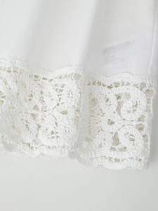 Gros plan détaillé sur tissu en coton blanc avec motifs ajourés en dentelle crochetée