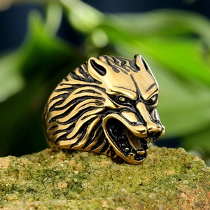 Vintage gold-toned wolf head ring in stainless steel displayed on mossy stone