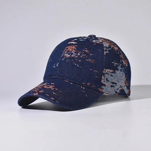 Detail of dark blue denim baseball cap with orange and white abstract dye patterns