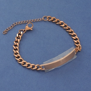 Macro shot of rose gold Cuban link bracelet with a blank ID plate and lobster clasp