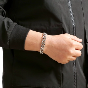 Classic silver stainless steel Cuban link bracelet for men and women on a black sleeve