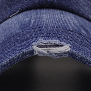 Macro shot of vintage denim baseball cap with distressed details and reinforced stitching