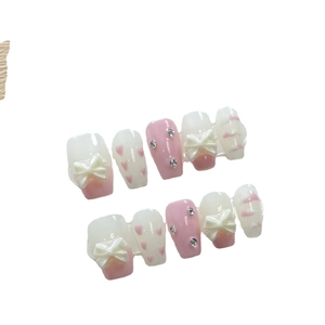 Pink and creamy white handmade press-on nails with 3D bows and heart patterns