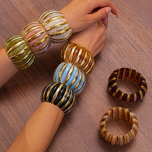 Detail of vintage ribbed acrylic bead bracelets with gold metal stripes and colorful resin