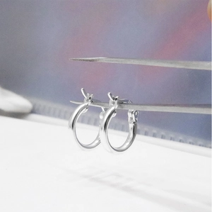 Close-up of polished S925 sterling silver hoop earrings with visible metal stamp detail